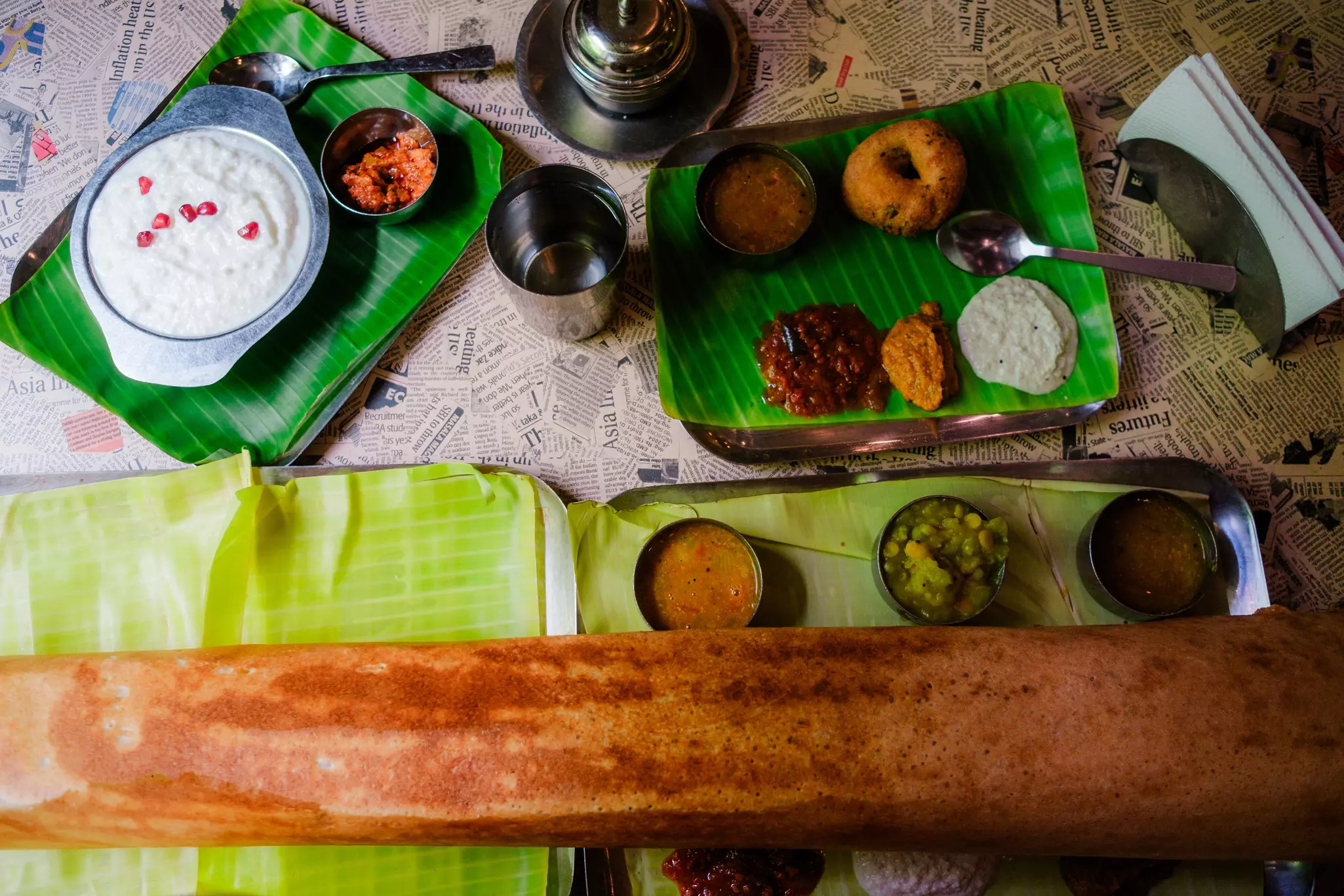 Crepe-like dosai (dosa), curd rice and vada served on banana leaves