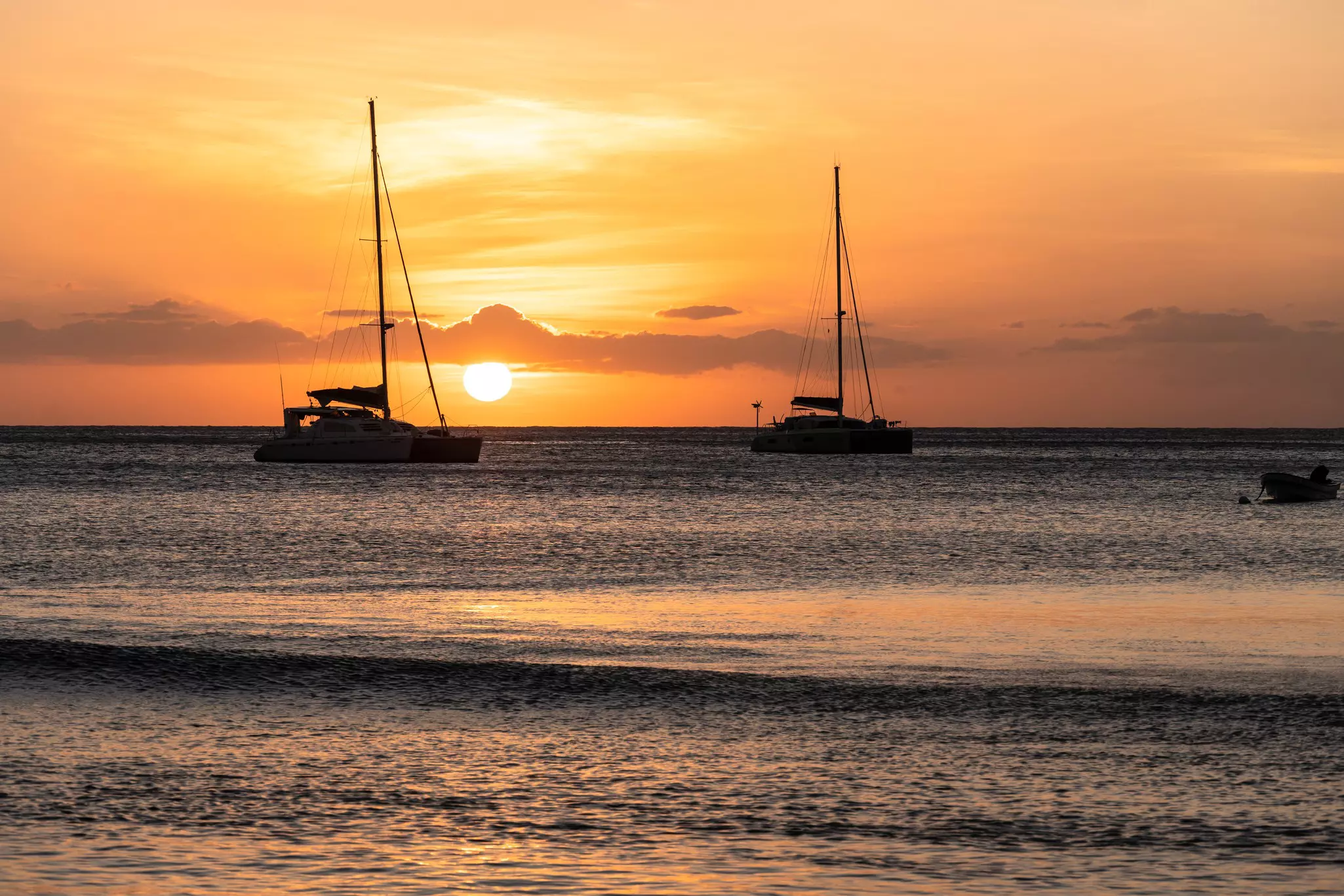 Sunset over two catamaran sailboats off the Yasawa island in Fiji