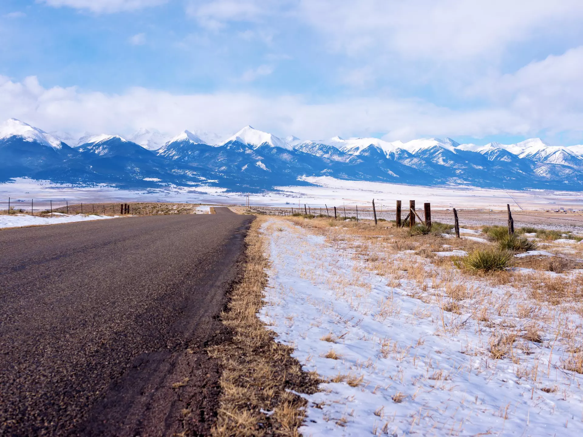 The Sangre De Cristo Mountains loom in the distance on the road from Westcliffe in Colorado. spates / Getty Images