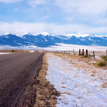 The Sangre De Cristo Mountains loom in the distance on the road from Westcliffe in Colorado. spates / Getty Images