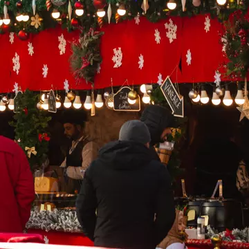 Christmas fair in winter. Traditional decorated Christmas fair kiosk with food cooked on site. People buy traditional food at the Christmas Market stall. Sibiu, Romania, December 18, 2023, License Type: media, Download Time: 2025-03-17T20:51:10.000Z, User: katelyn.perry_lonelyplanet, Editorial: true, purchase_order: 65050 - Digital Destinations and Articles, job: wip, client: wip, other: Katelyn Perry