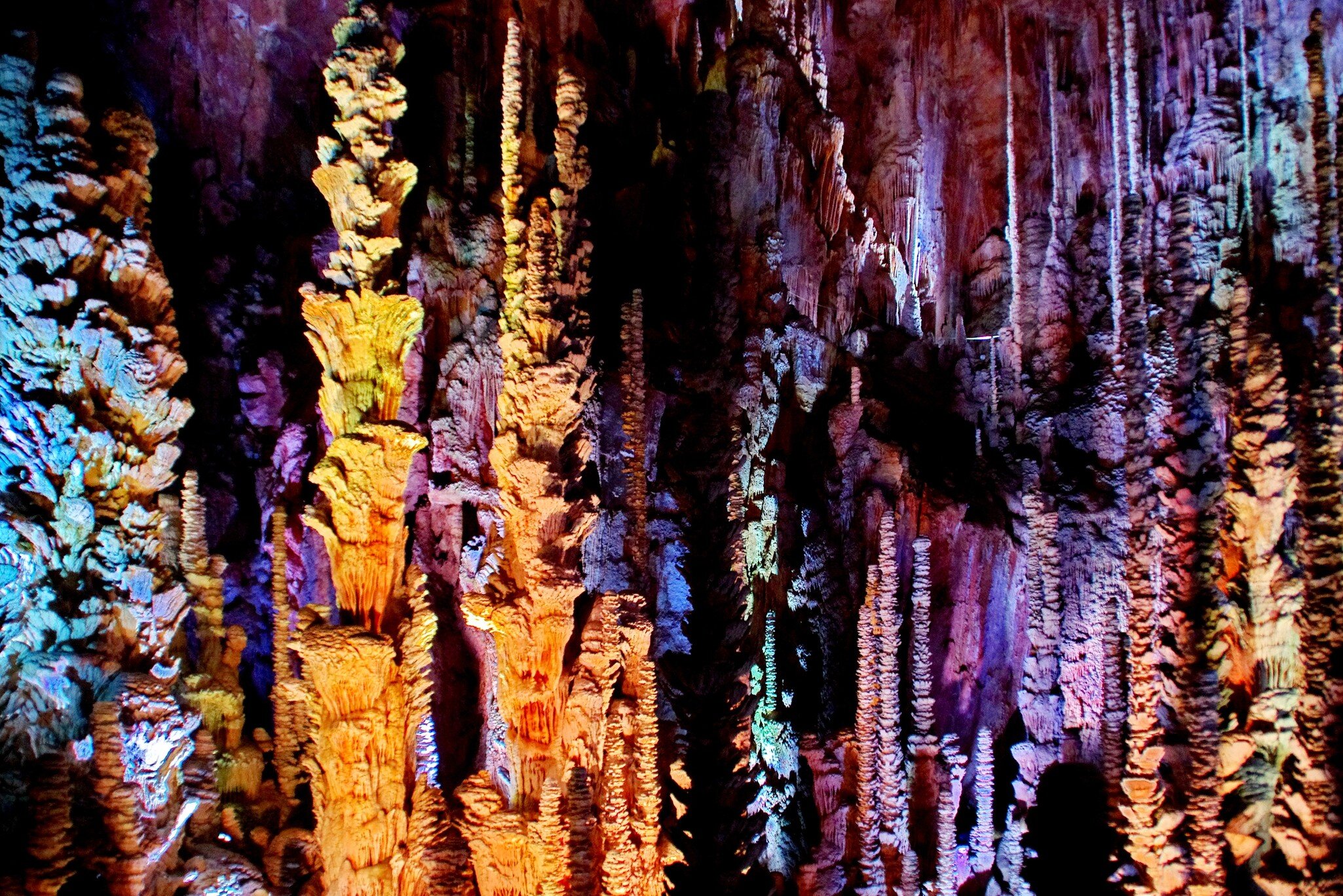 Stalactites and stalagmites lit with multicolored lights in the Aven Armand cave; Shutterstock ID 1800747391;