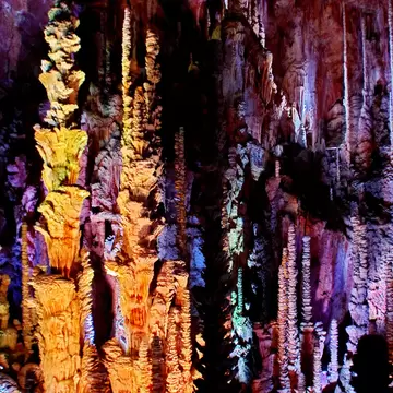 Stalactites and stalagmites lit with multicolored lights in the Aven Armand cave; Shutterstock ID 1800747391;