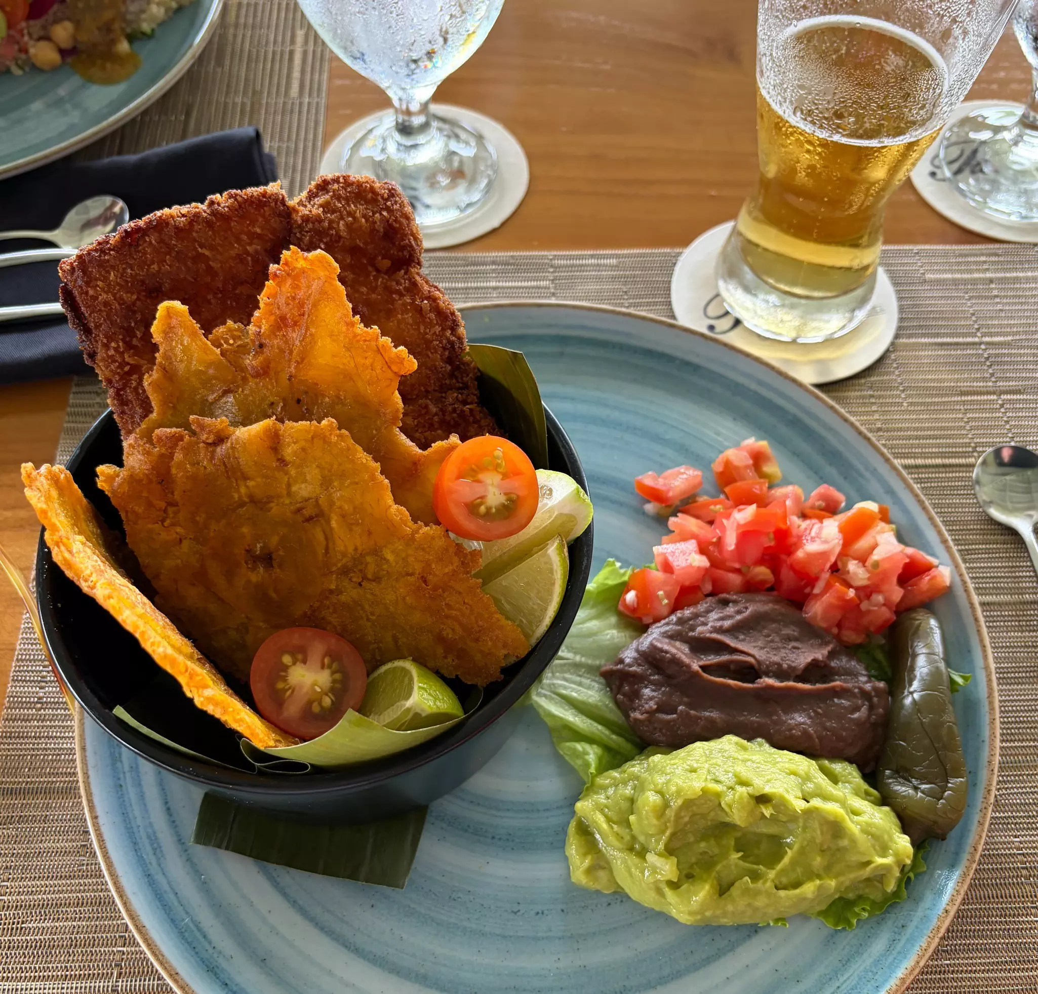 Patacones with avocado, refried beans and a beer at a hotel restaurant in Costa Rica. 
