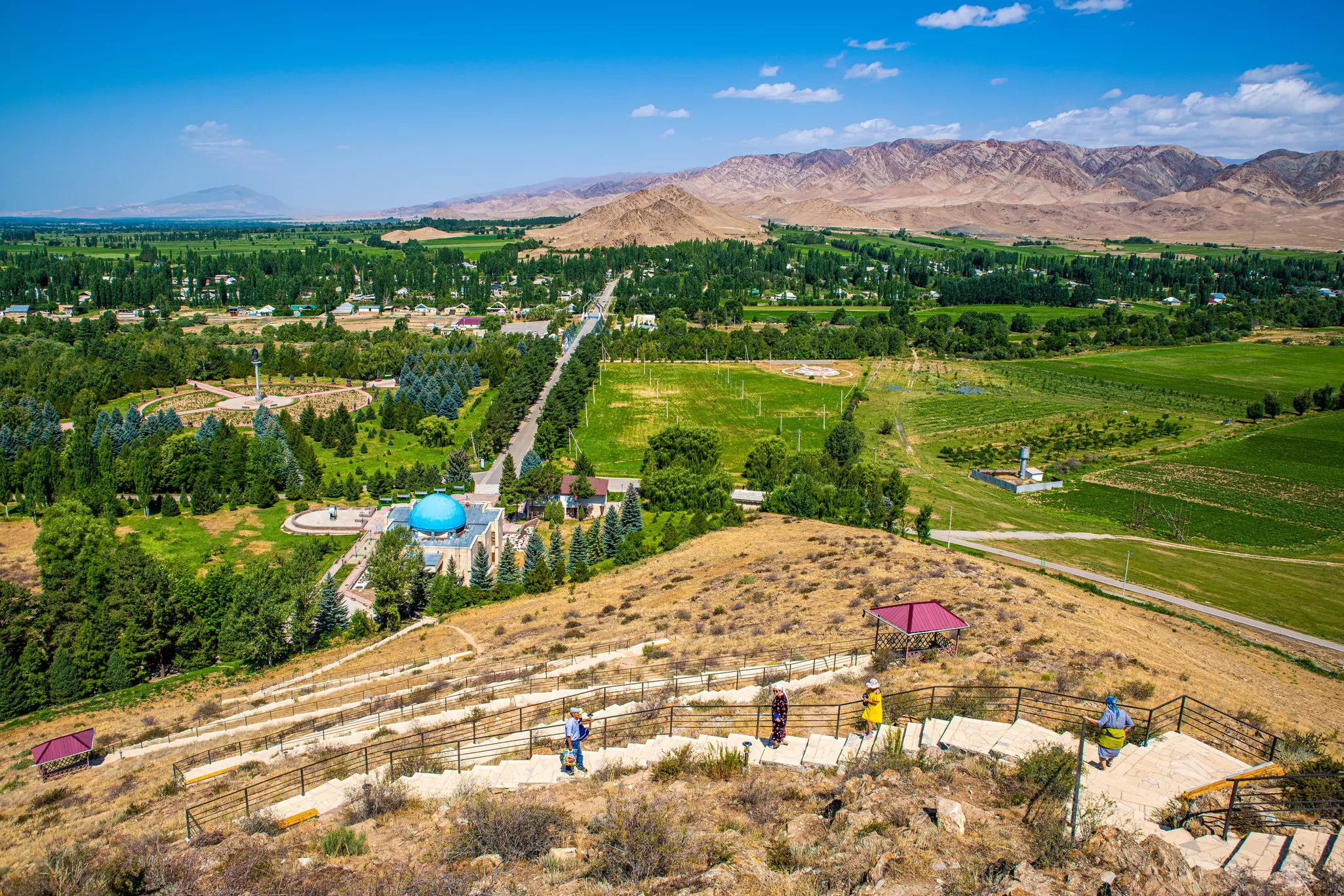 People visit a mausoleum in a rural landscape