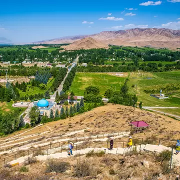 People visit a mausoleum in a rural landscape