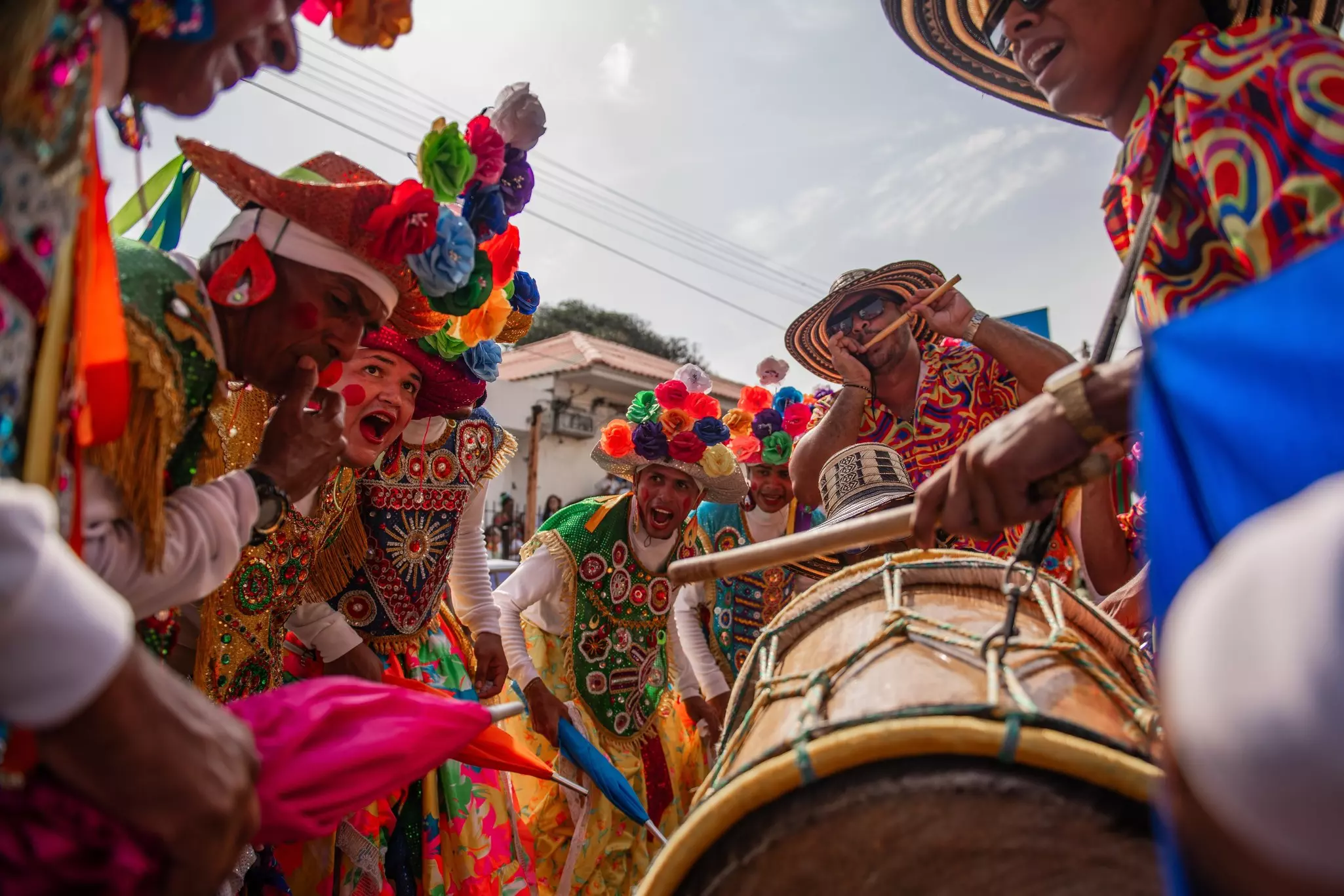 People dance, sing, and play drums in traditional dress.