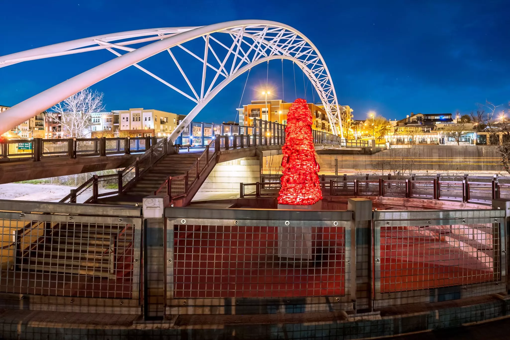 The Highland Pedestrian Bridge links the Highland neighborhood and Downtown Denver, lit up by John McEnroe's <em>National Velvet</em> sculpture © joe daniel price / Getty Images