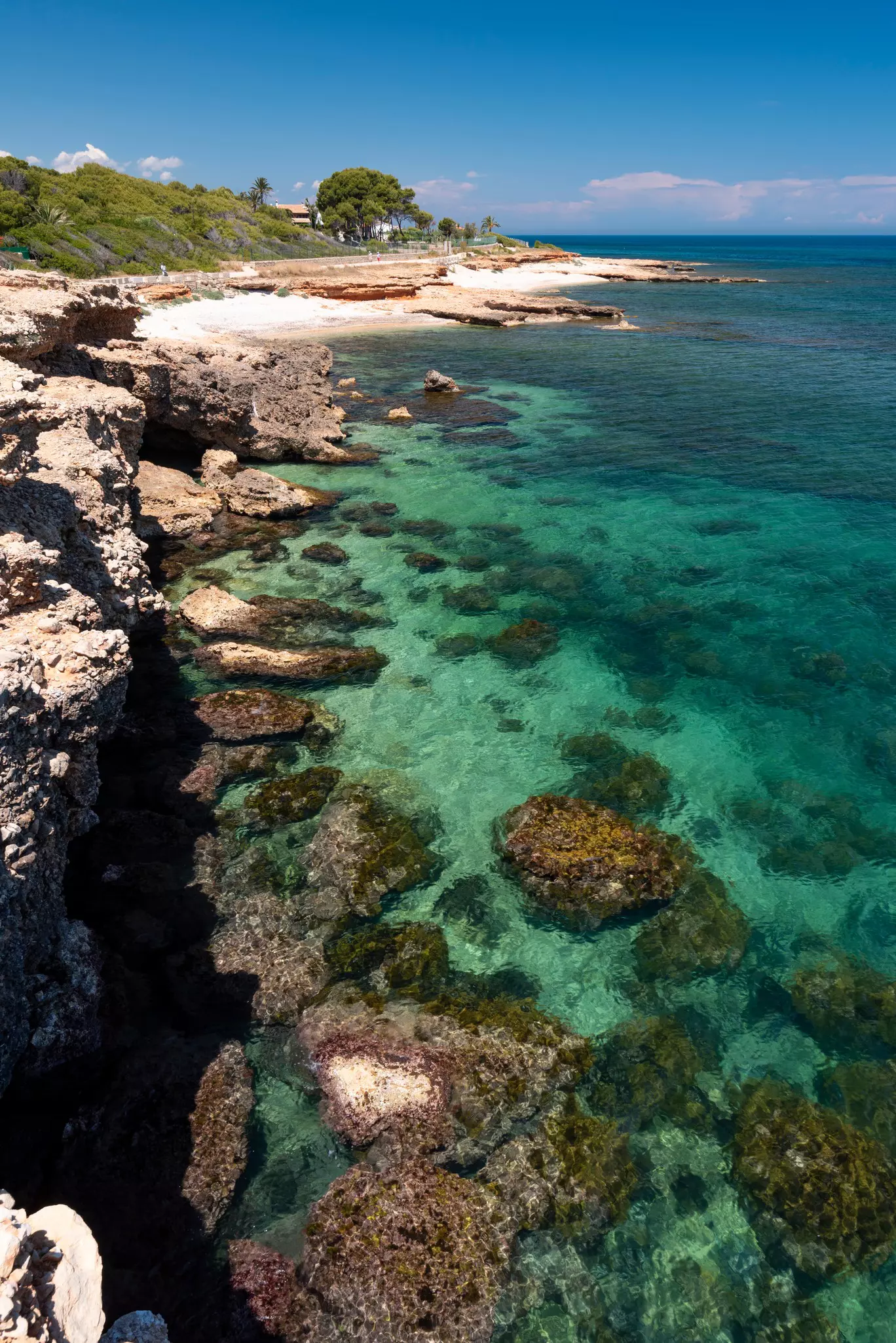 A rocky coastline with several sandy coves tucked into the shore.
