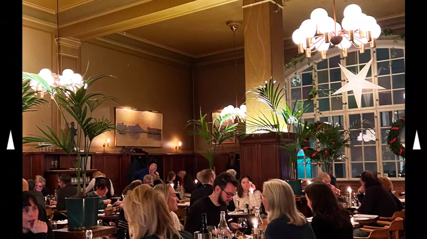 A dinner scene in a dimly-lit and elegant restaurant in Stockholm