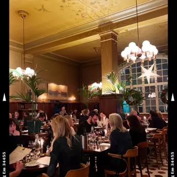 A dinner scene in a dimly-lit and elegant restaurant in Stockholm