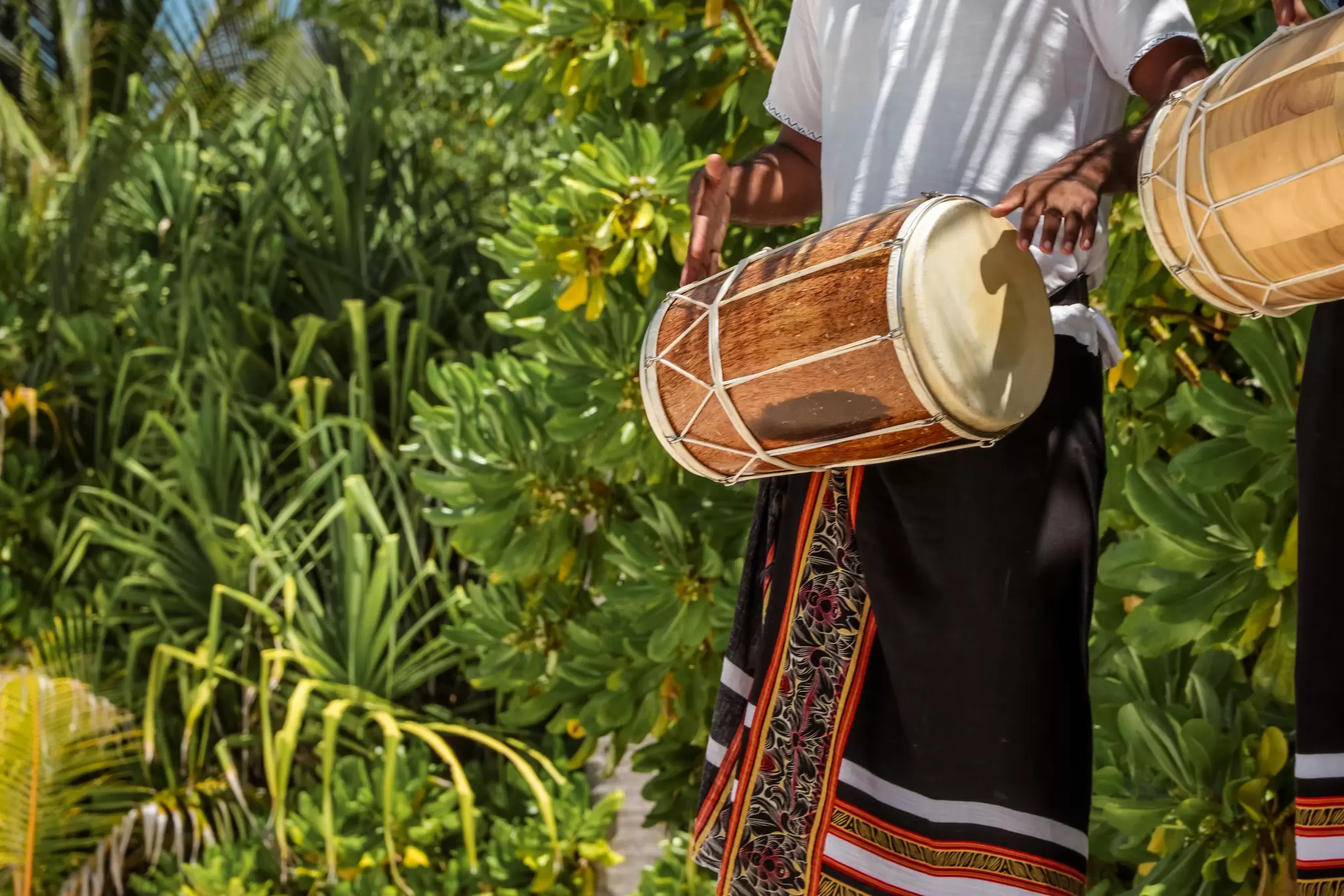 Two performers hold a large drum each during a traditional drumming performance in the Maldives