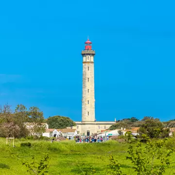 Green field and Phare des Baleines lighthouse in Saint-Clément-des-Baleines, France