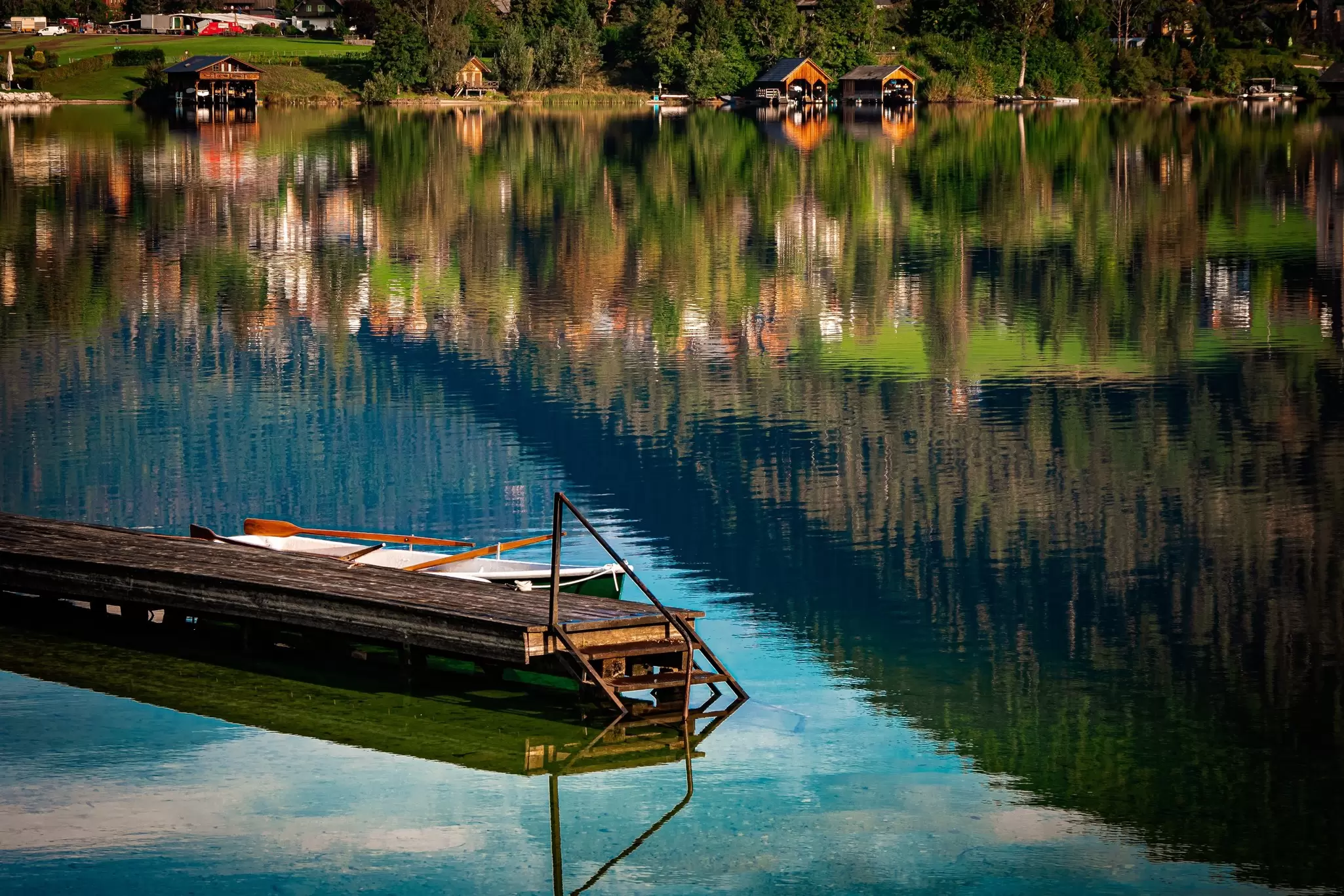 A wooden jetty on a lake, with reflections on the surface