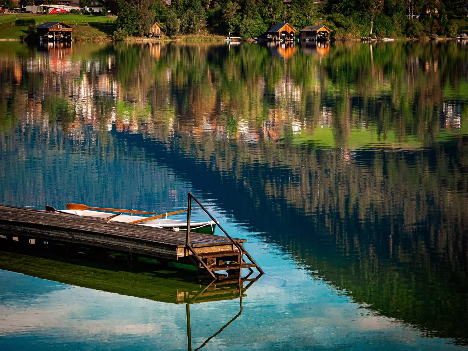 A wooden jetty on a lake, with reflections on the surface