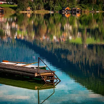 A wooden jetty on a lake, with reflections on the surface