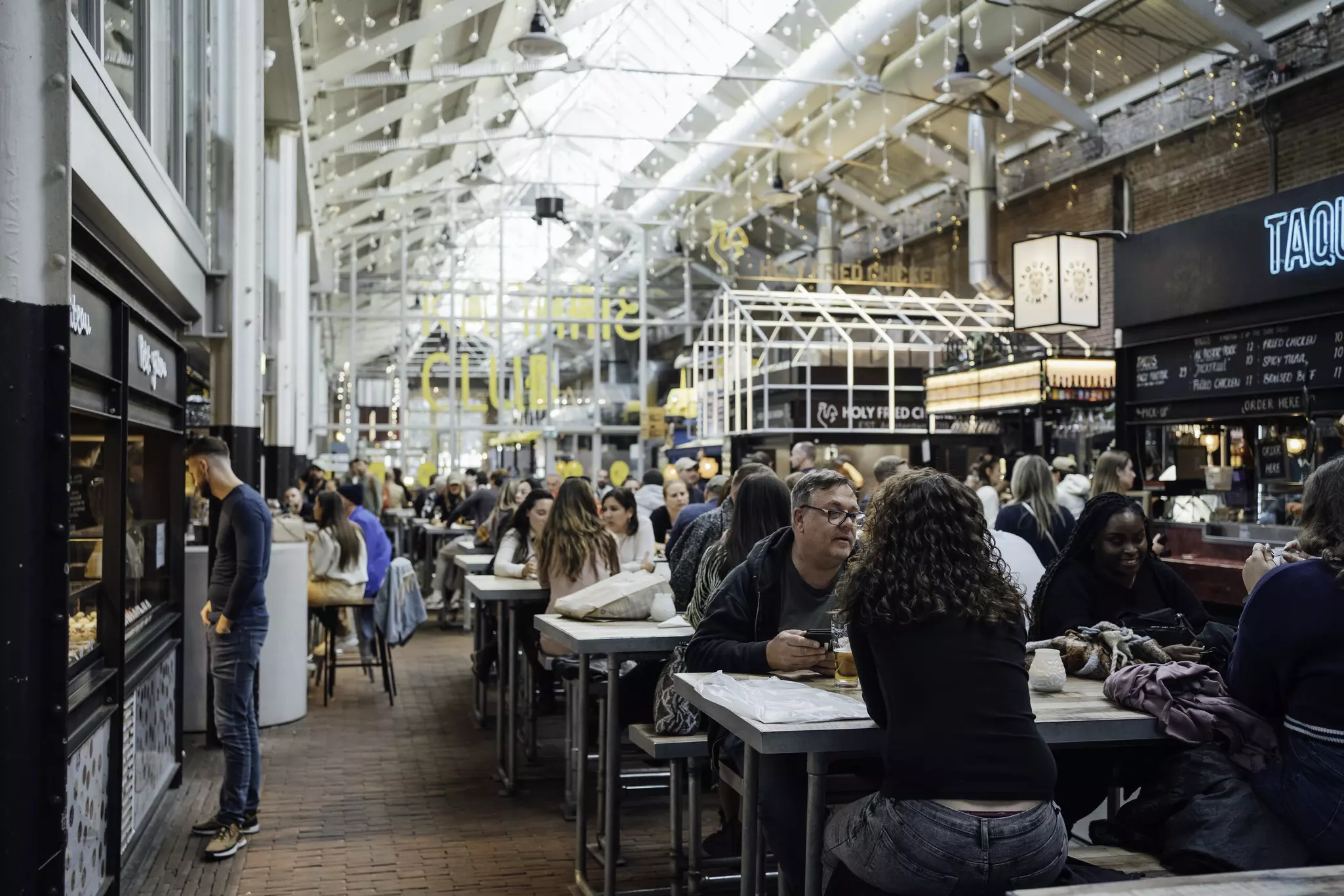 People eating at tables in a popular food court