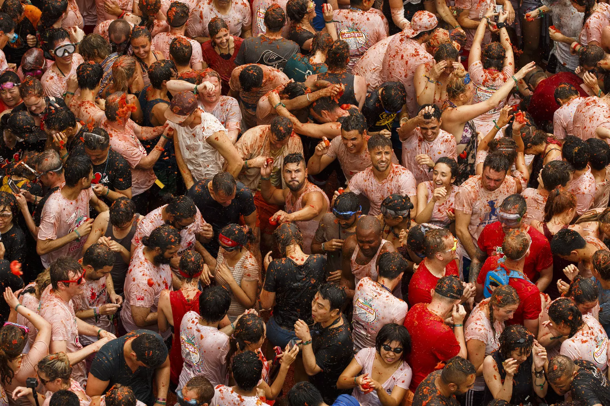 A large crowd of people enjoying the atmosphere at a Spanish tomato throwing festival