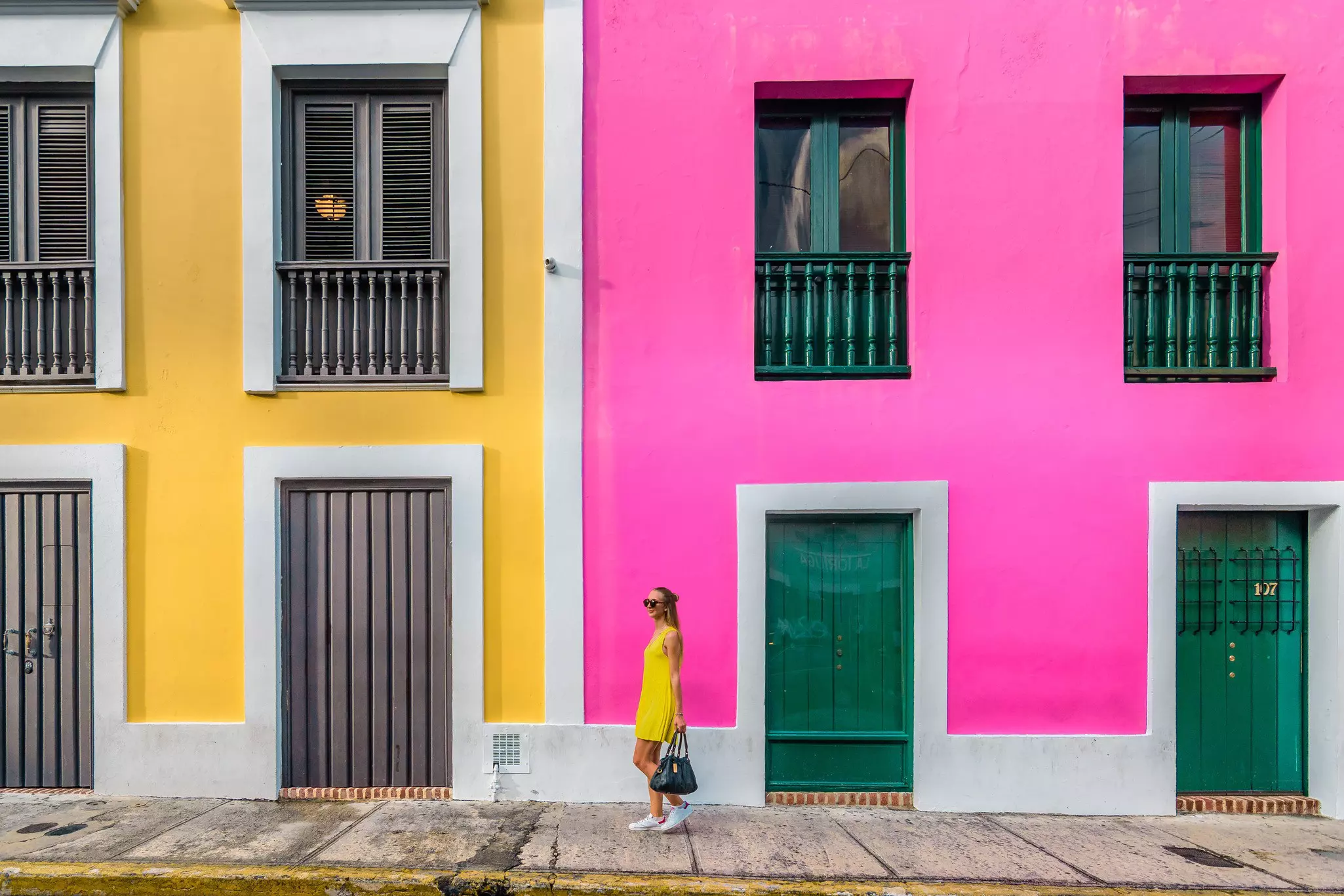 Woman in a yellow dress in front of colorful facades in Old San Juan