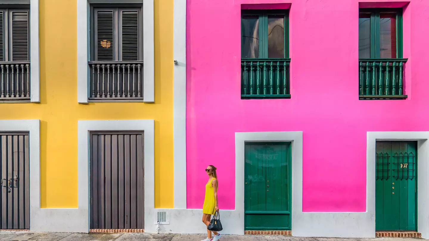 Woman in a yellow dress in front of colorful facades in Old San Juan
