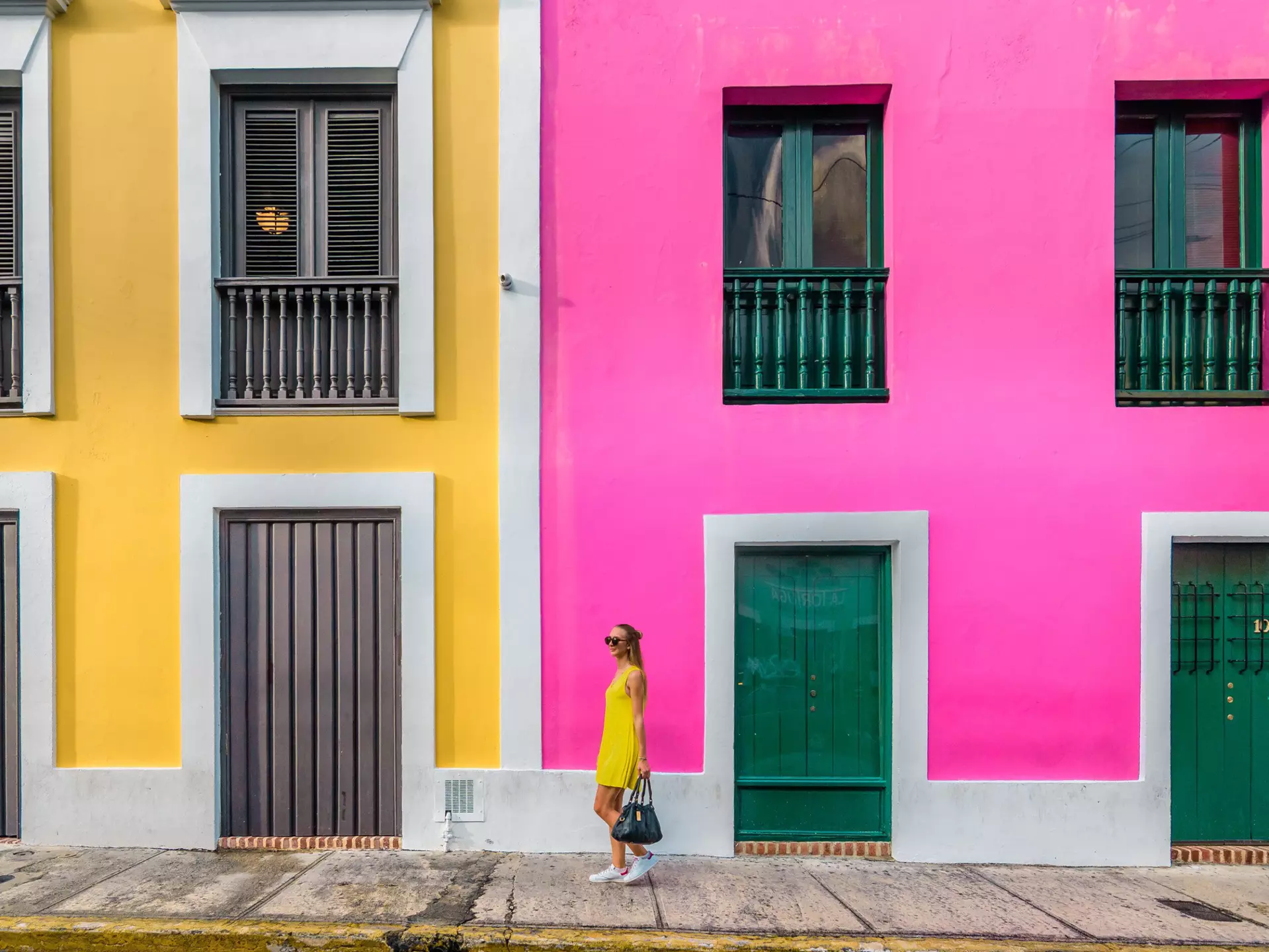 Woman in a yellow dress in front of colorful facades in Old San Juan