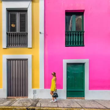 Woman in a yellow dress in front of colorful facades in Old San Juan