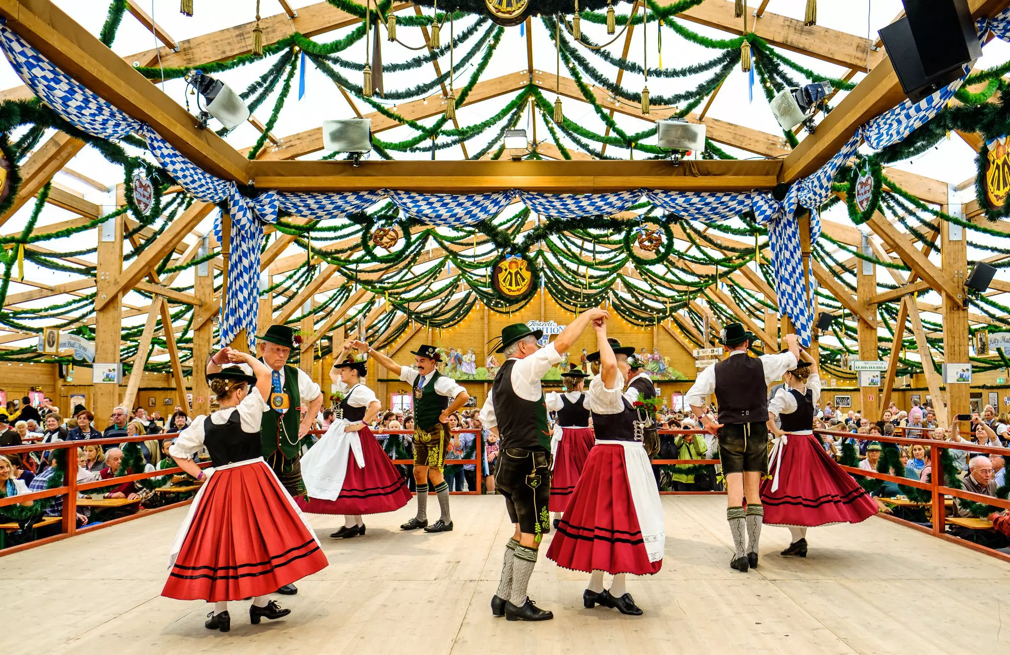 Couples dance in traditional costumes inside a beer tent during Oktoberfest © FooTToo / Shutterstock