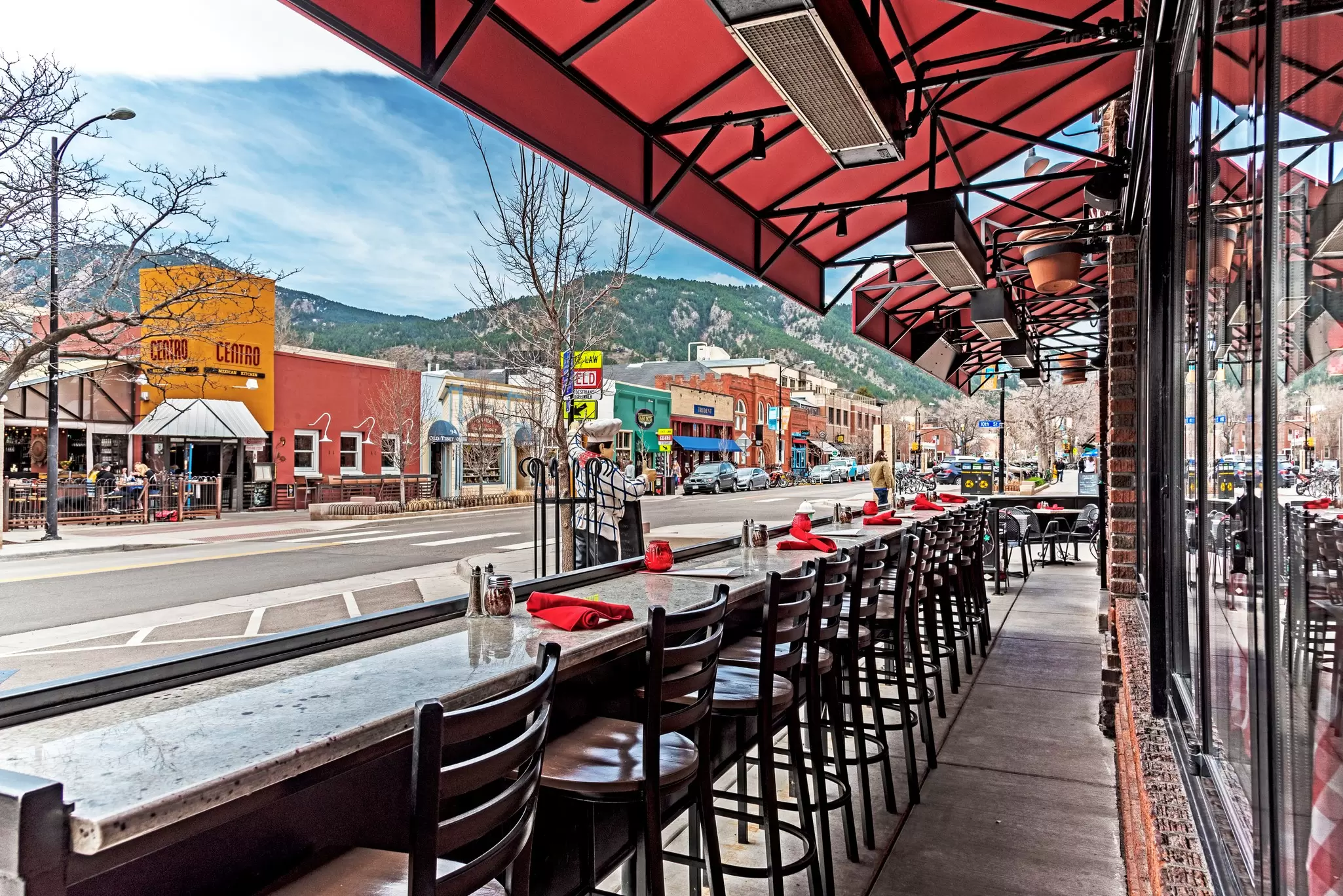 Stools line a street-facing counter outside a restaurant on Pearl Street in Boulder, Colorado