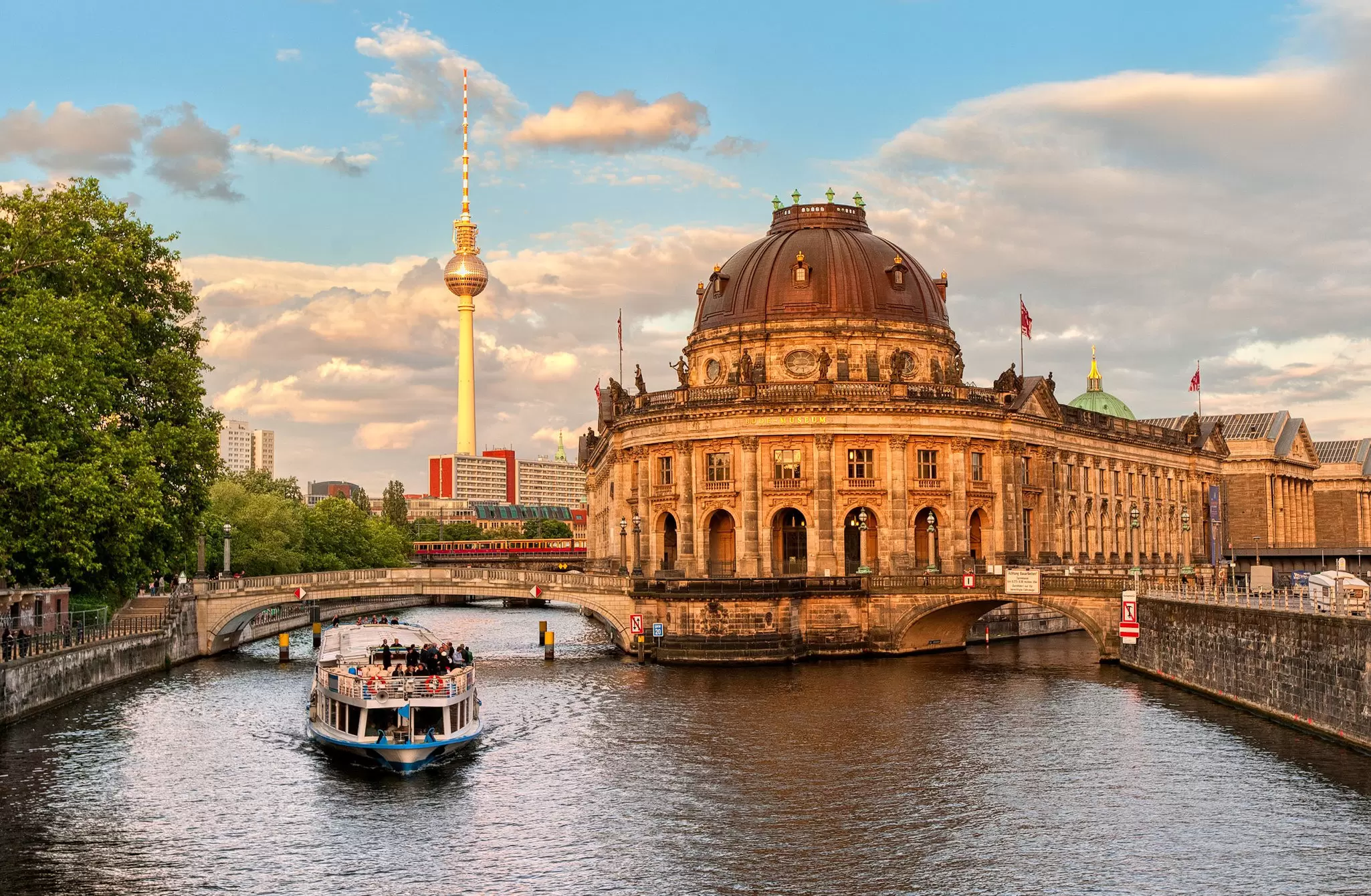 Museumsinsel, a small island home to five museums, on the River Spree in Berlin. A passenger ferry passes the island on the river.
