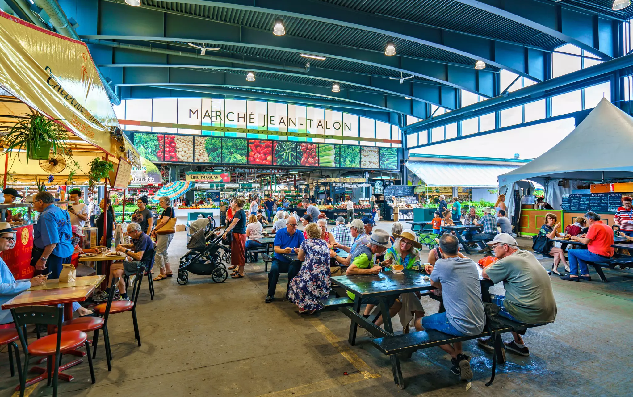 People eating at picnic tables in Marché Jean-Talon. NoyanYalcin/Shutterstock