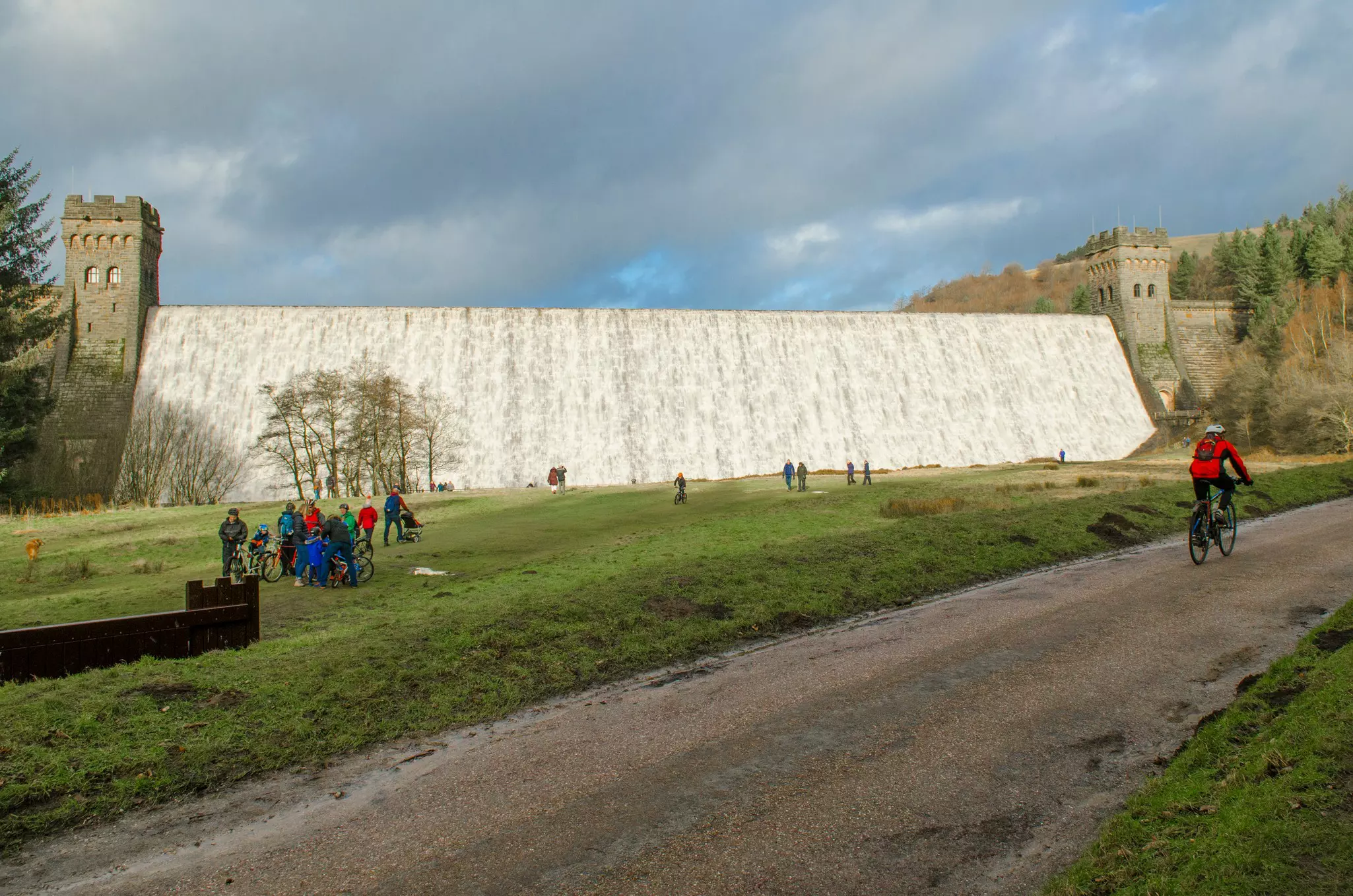 A mountain biker cycling past the Derwent Dam on Ladybower Reservoir in the Peak District, England