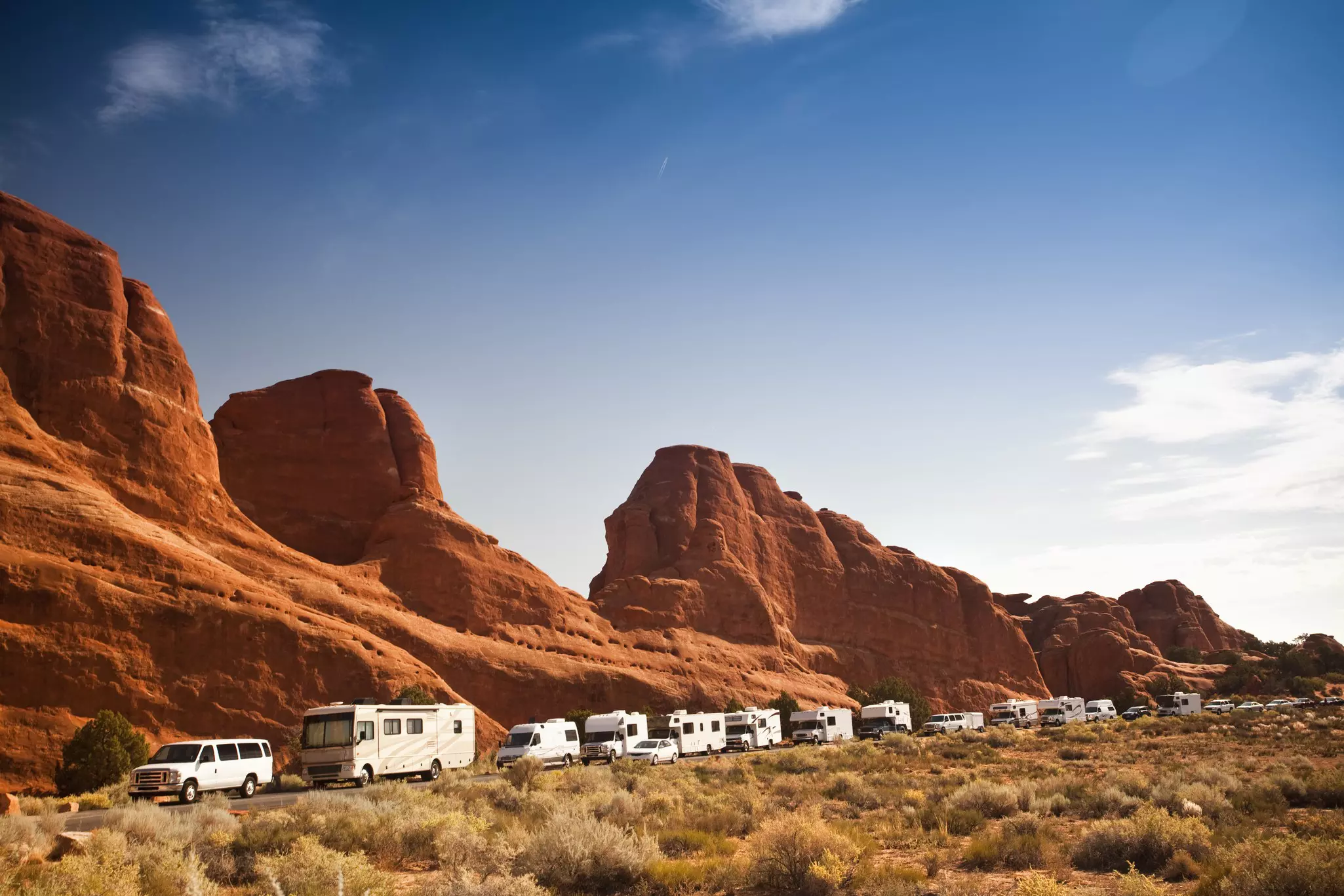 Motor-home campers on the road in red rock landscape in Arches National Park.