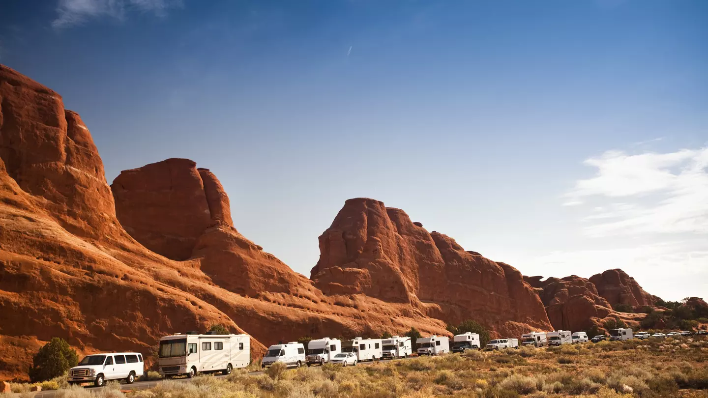 Motor-home campers on the road in red rock landscape in Arches National Park.