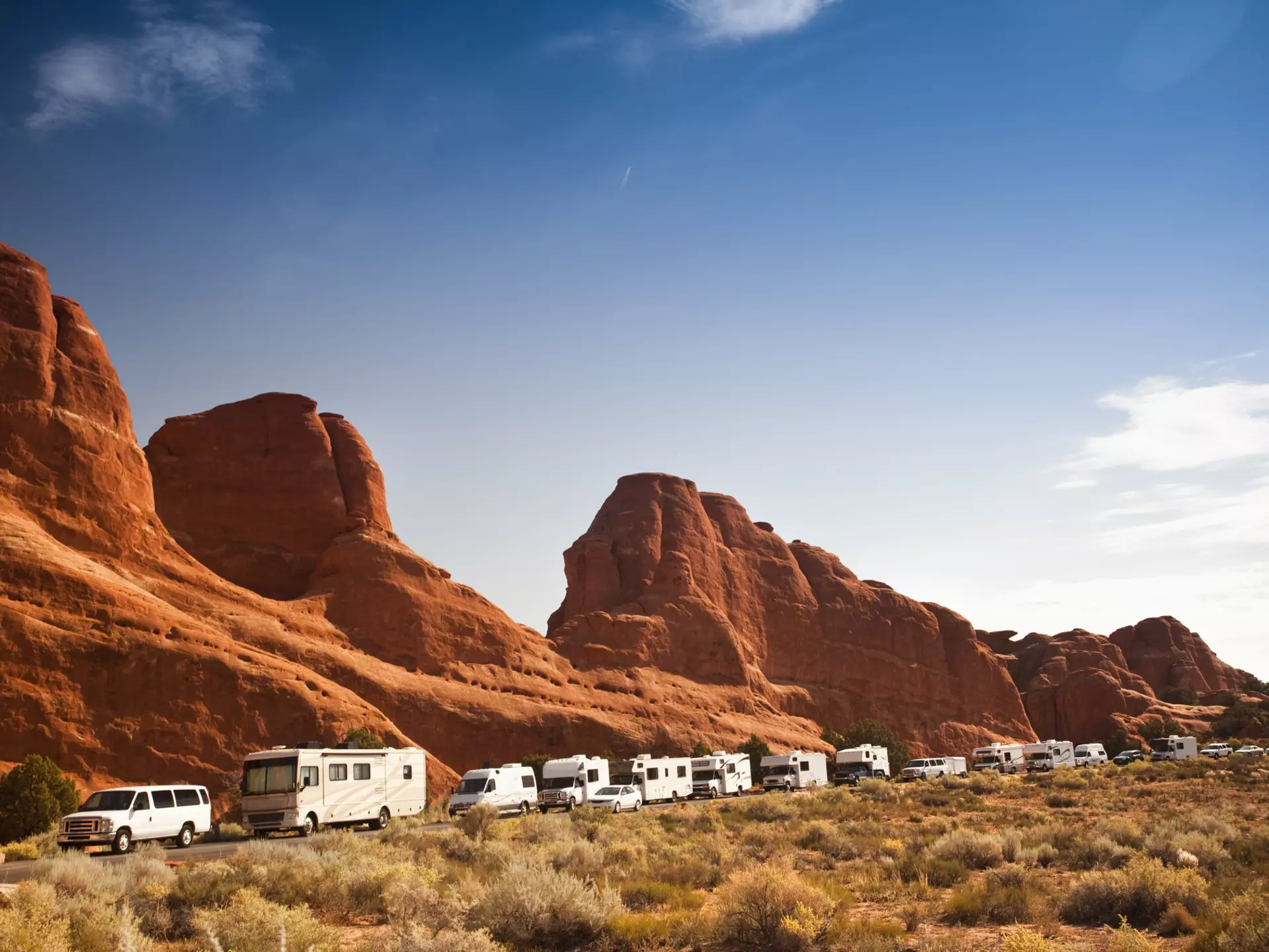 Motor-home campers on the road in red rock landscape in Arches National Park.