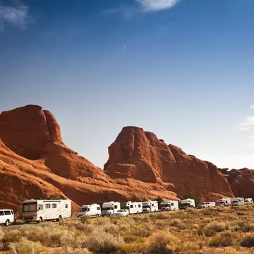 Motor-home campers on the road in red rock landscape in Arches National Park.