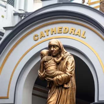 Detail of a gold statue in front of the facade of the Holy Rosary Cathedral in Kolkata, India.