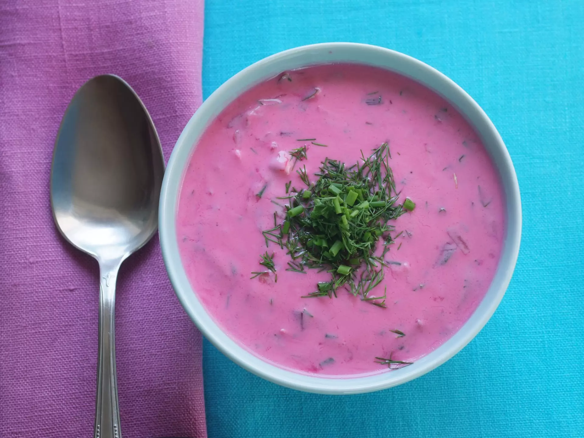 Traditional Polish cold beetroot soup in a bowl on a tablecloth with a napkin. Geo-grafika / Getty Images