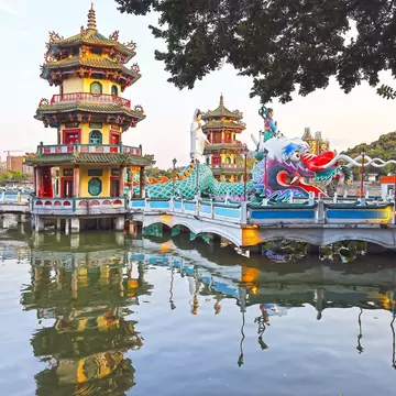 Red and gold pagodas with a green dragon coming out of it, floating on Lotus Pond in Kaohsiung.