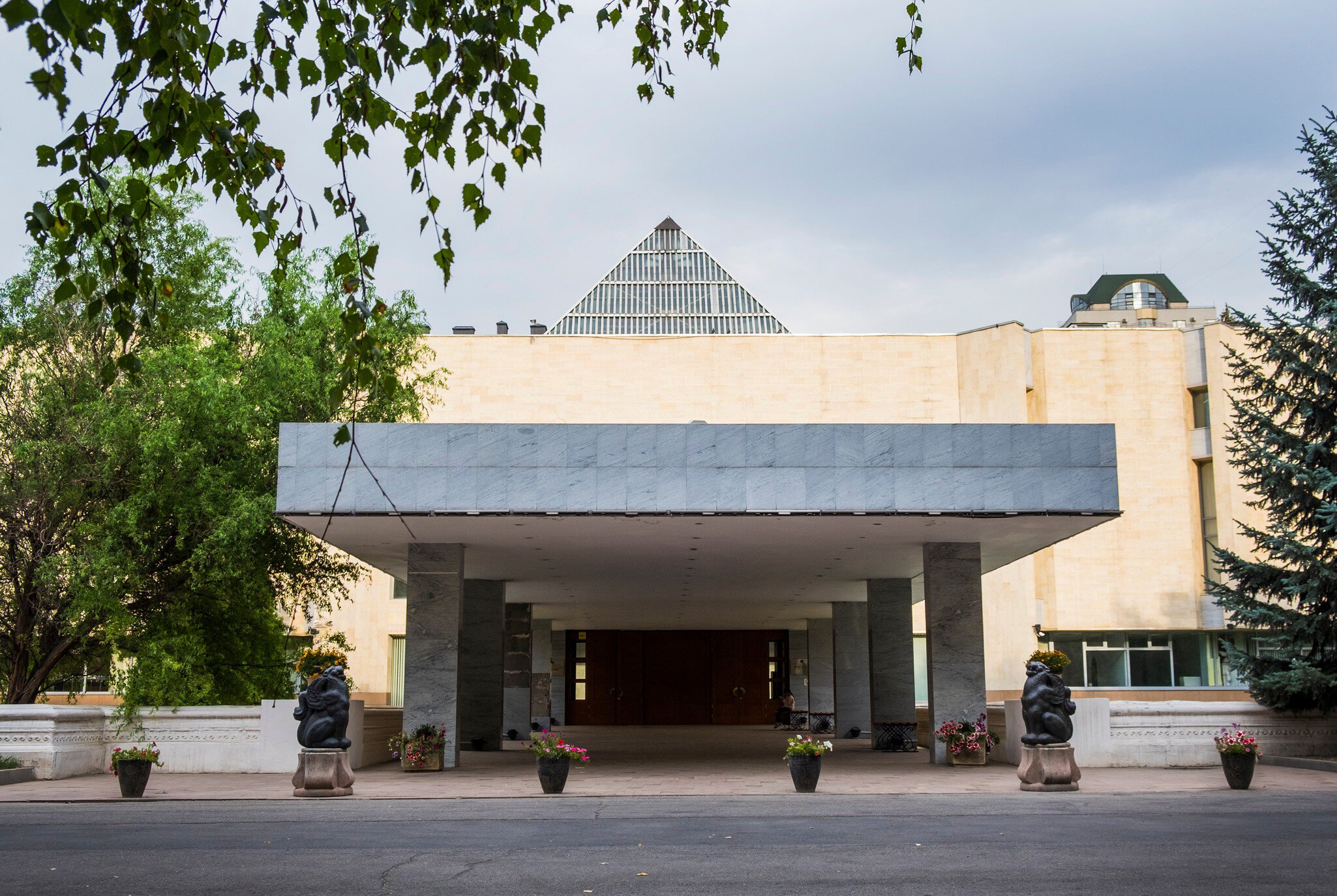 A modern museum entrance with a flat canopy, square pillars and bear statues.