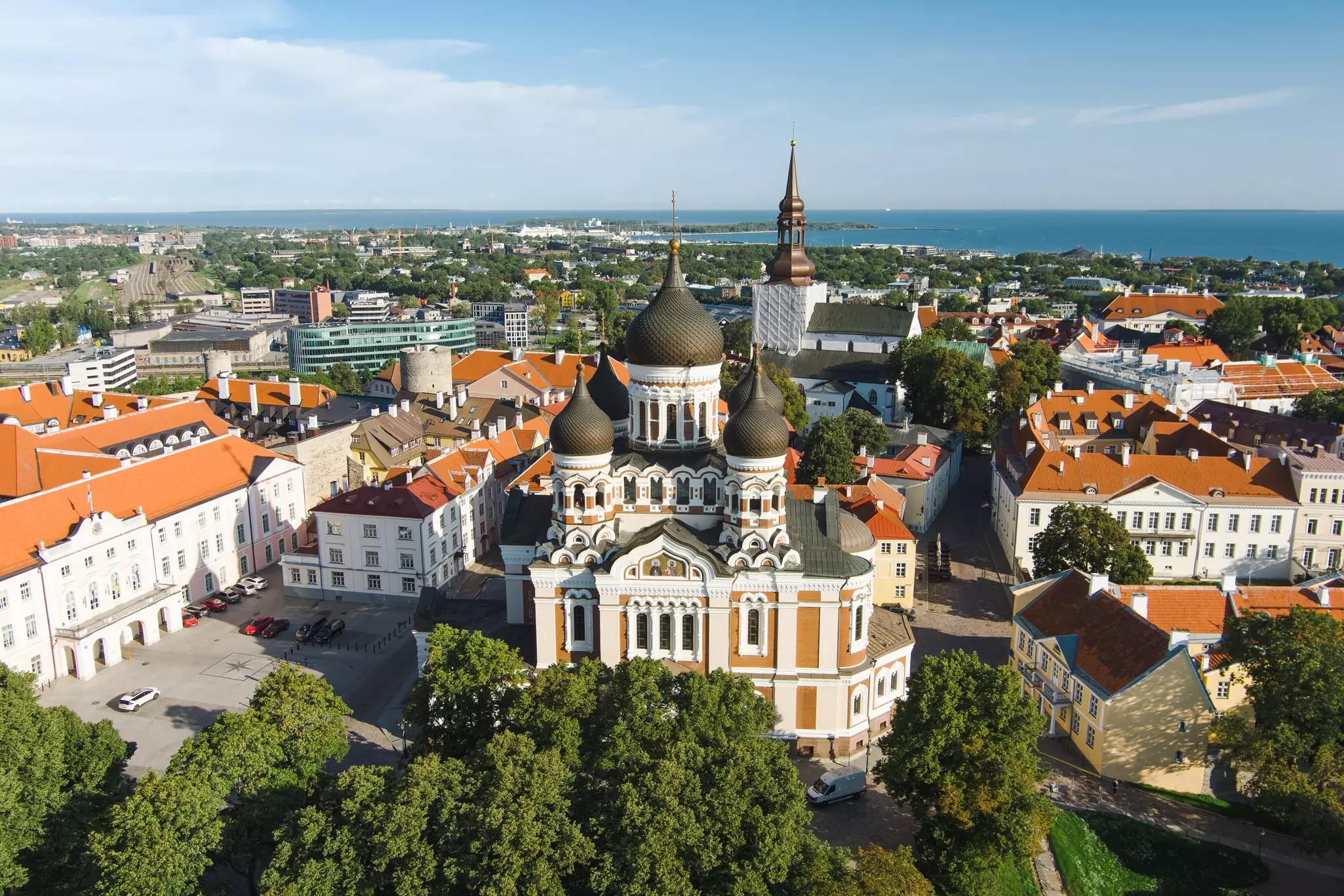 Aerial view of ornate cathedral surrounded by white buildings with red roofs on a sunny day.