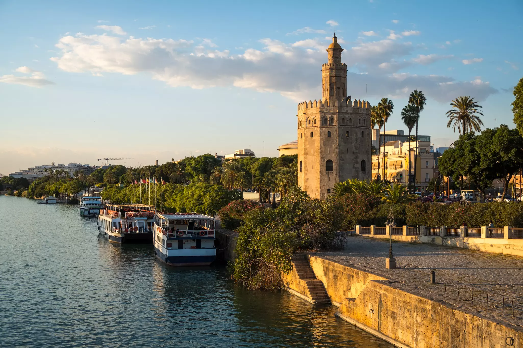 A stone tower by a river at sunset.