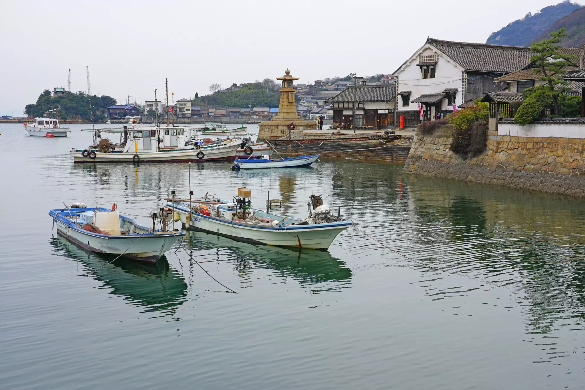 Fishing boats are moored in the harbor of small town.