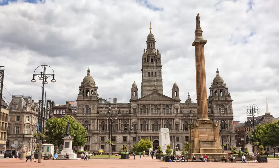 An ornate building on Glasgow's George Square with people milling about.