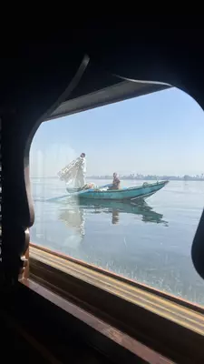 River vendors as seen from the window of river cruise boat on the Nile. Vendors approach boats when they pass through the locks system on the Nile, attempting to sell their wares to passengers.