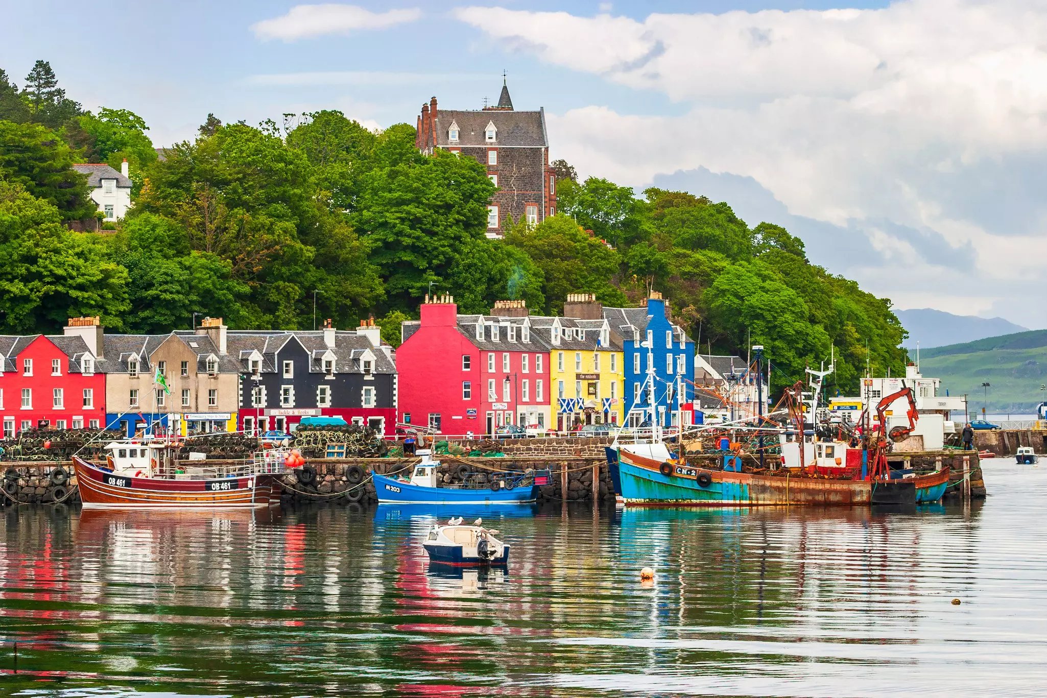 Colorful houses and boats in Tobermory harbor, Mull, Scotland.