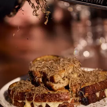 Black truffle grated on a grilled cheese sandwich at The Truffle Farm in Tasmania, Australia. 