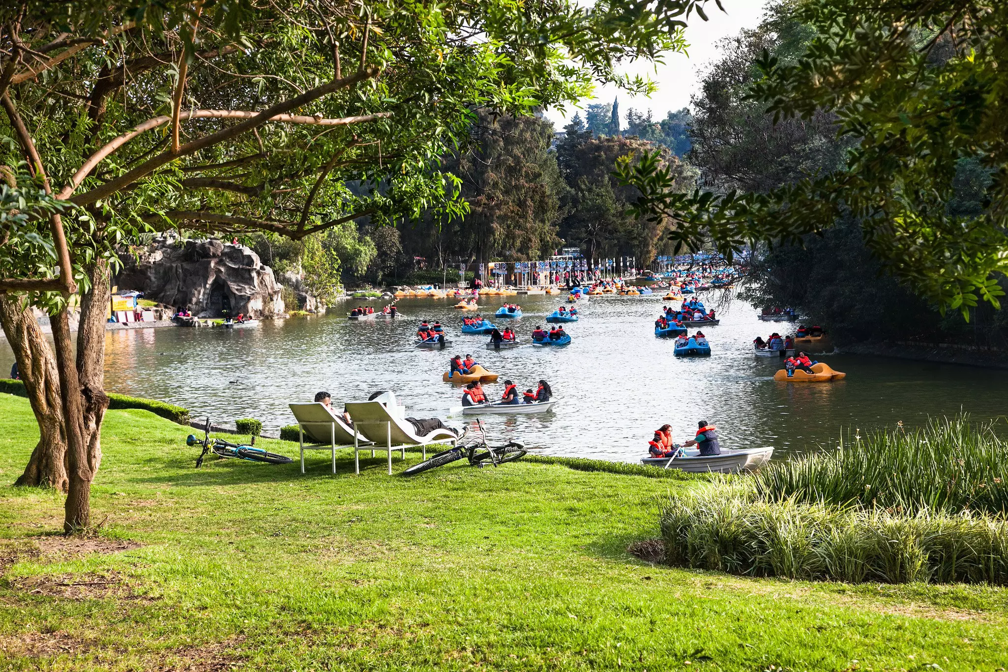 Families out on small boats on a lake in parkland