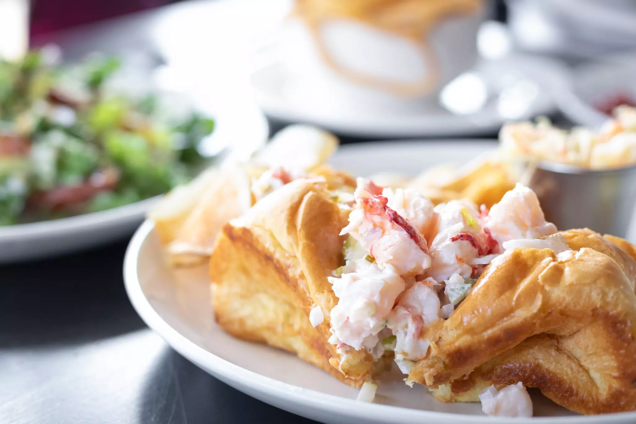 Close up on a gourmet lobster roll sandwich tossed in mayonnaise