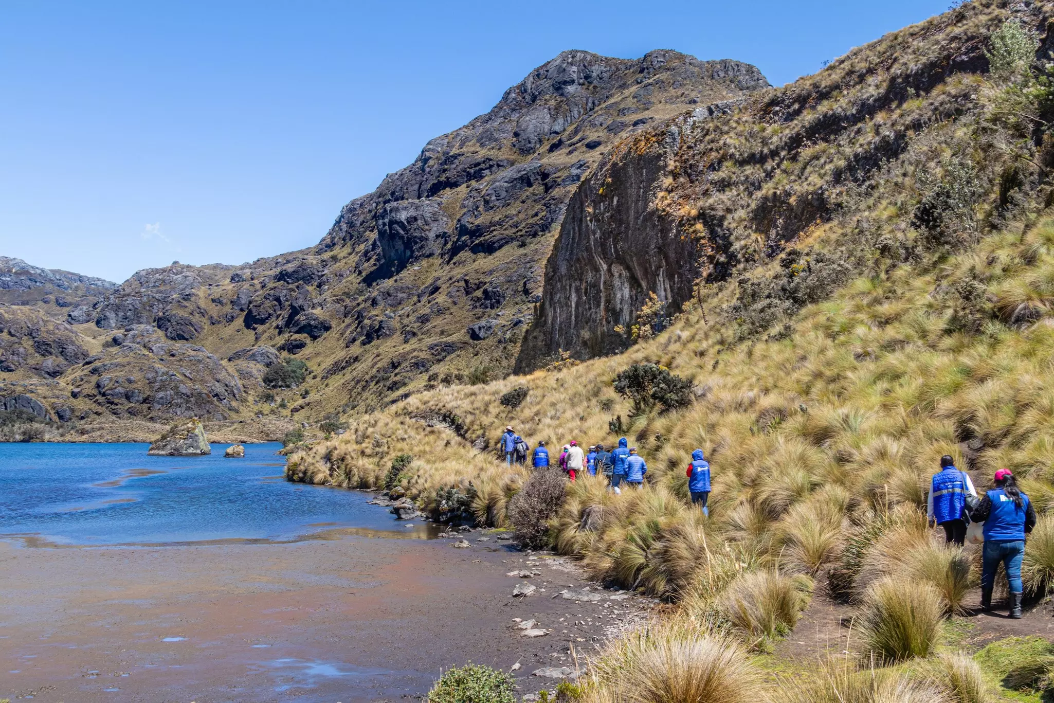 Hikers on a trail around a lake in the mountains of Ecuador near Cuenca.