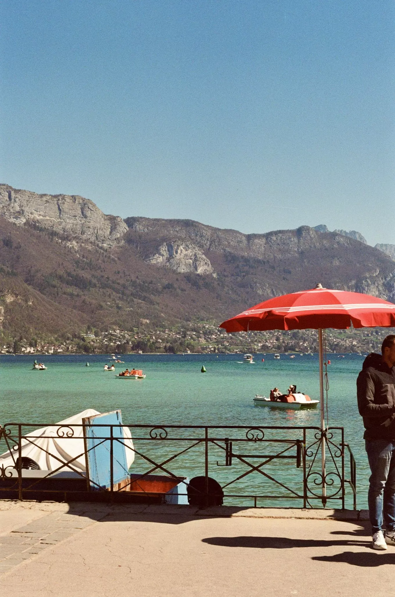 People on paddle boats on an alpine lake in the sunshine